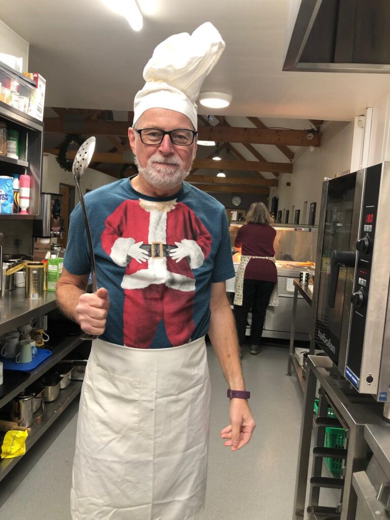 Man in santa shirt and ladle in kitchen