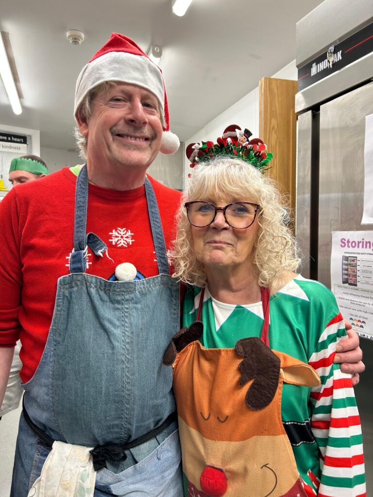 Man with hands around woman wearing Christmas clothes