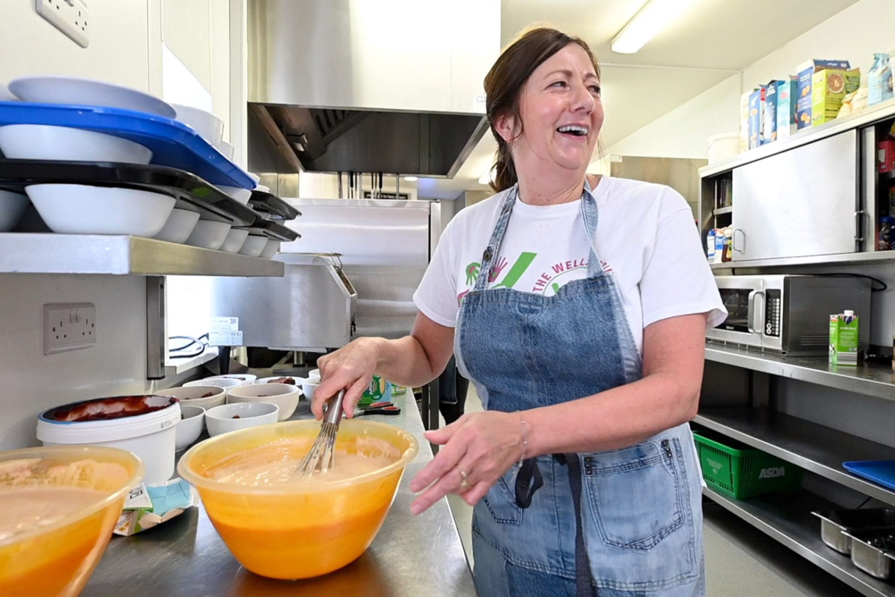 Woman smiling mixing food in a kitchen