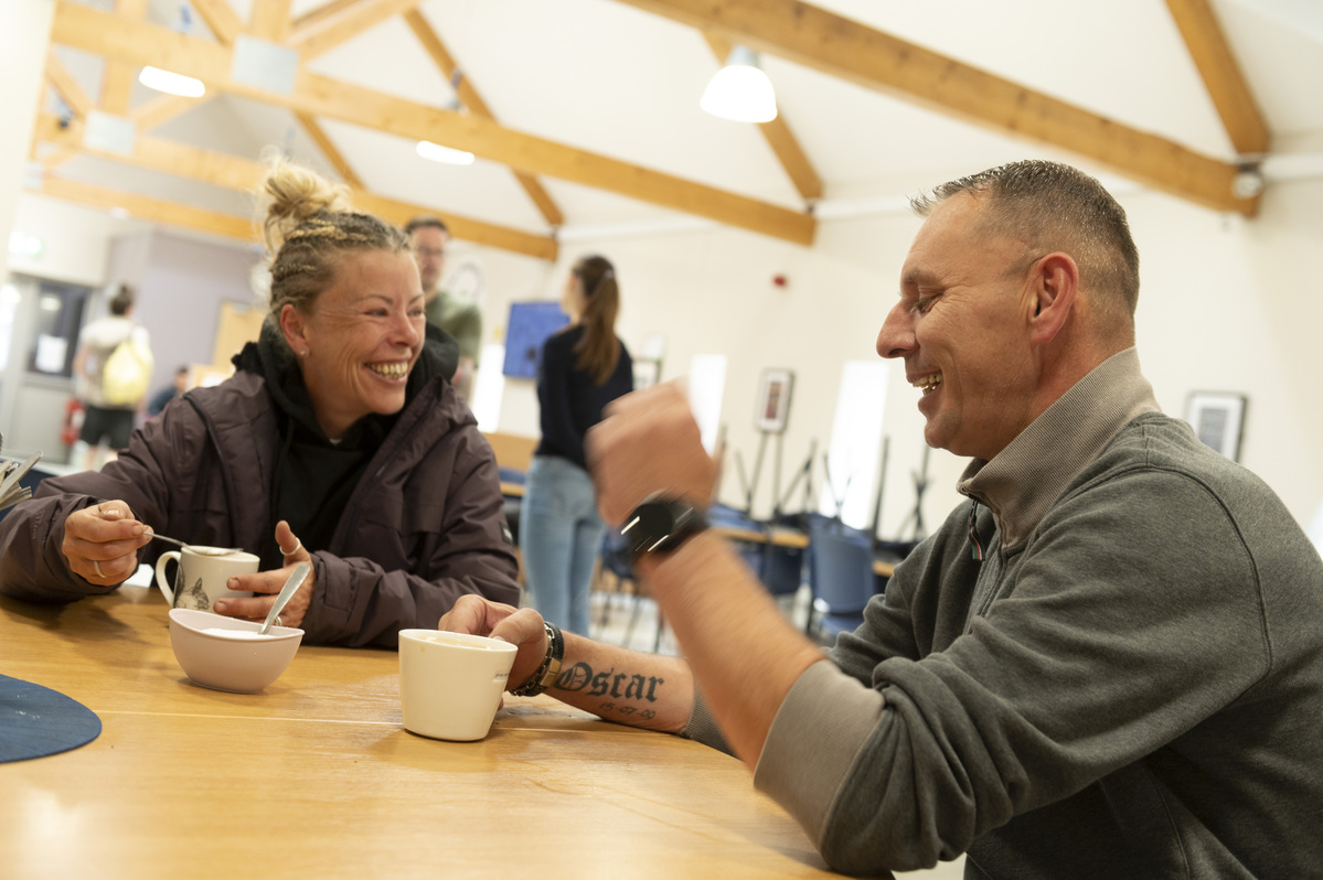 Man and woman laughing with cups in their hands